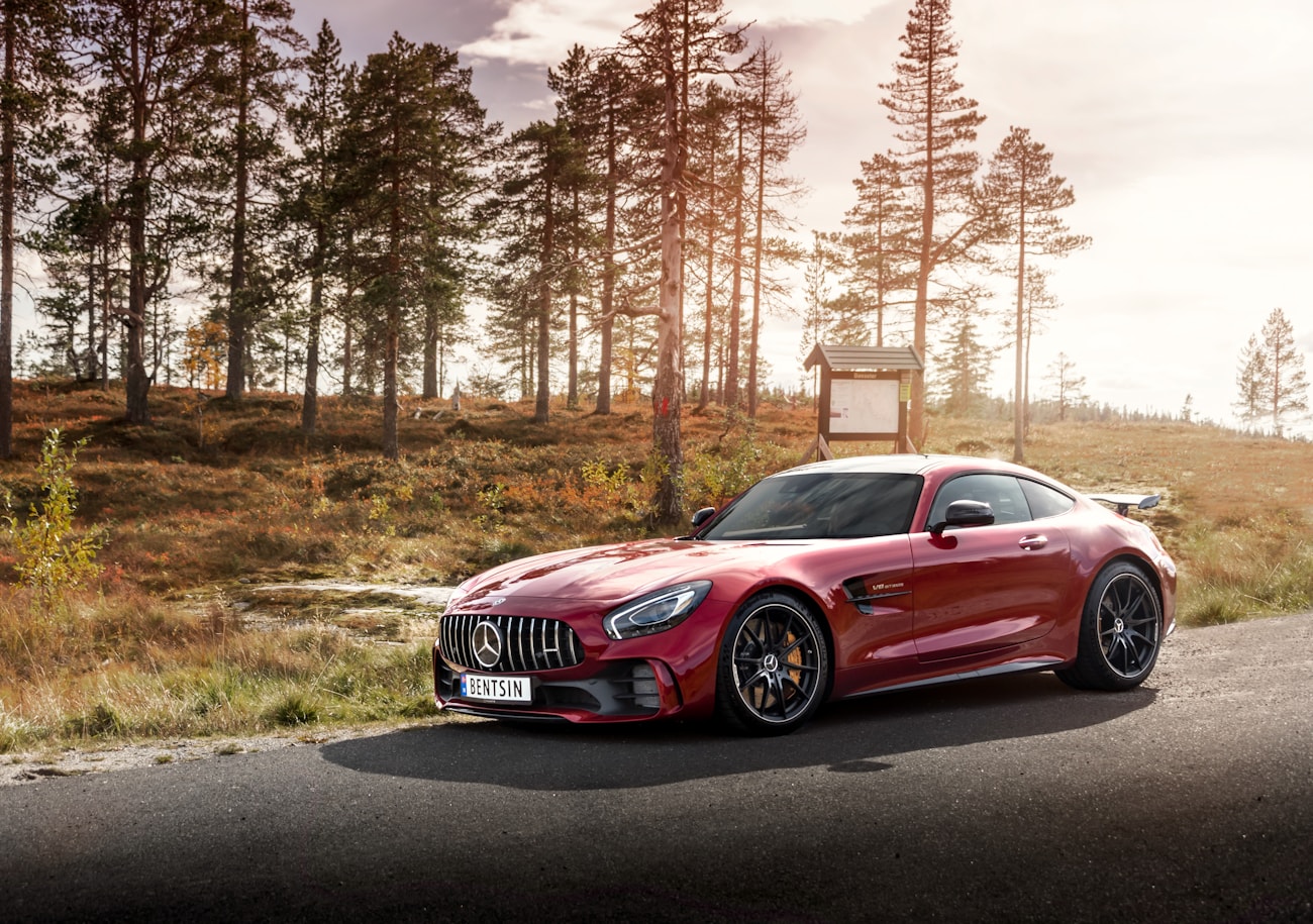 Красный Mercedes-AMG GT R на лесной дороге в золотом свете